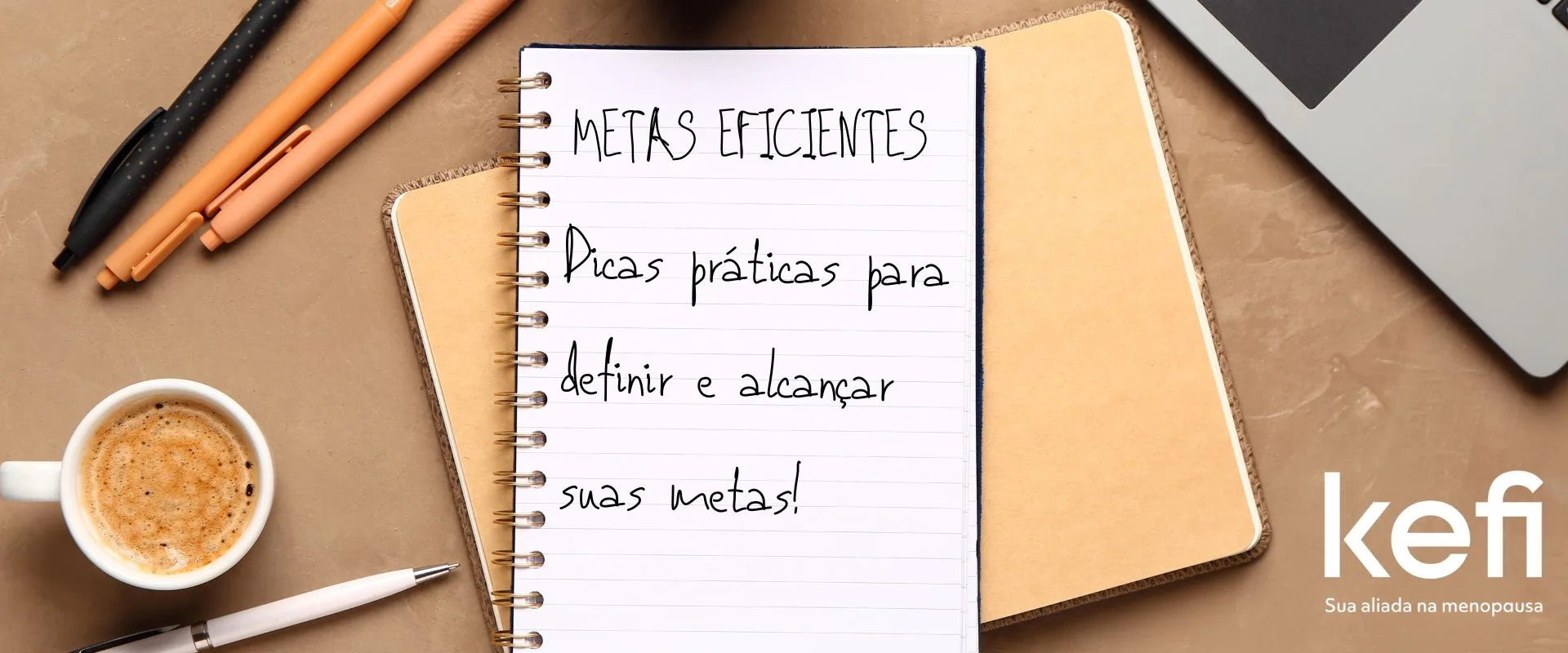 Imagem de capa para um artigo com um caderno espiral aberto no centro, sobre uma superfície de cor bege, com a inscrição 'Metas eficientes - Dicas práticas para definir e alcançar suas metas!' escrita a mão em letras grandes. Ao lado do caderno, há três canetas estilosas e uma xícara de café cheia, indicando um momento de planejamento e reflexão. No canto inferior direito, sobre um laptop fechado, está o logo da Kefi com o slogan 'Sua aliada na menopausa', reforçando a identidade da marca. A composição da imagem sugere organização e inspira a ação de estabelecer objetivos pessoais
