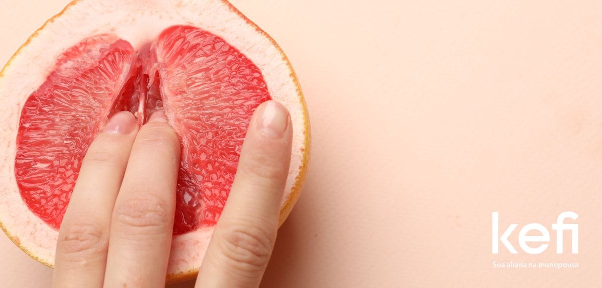 Imagem de capa para o artigo 'Mitos e Verdades sobre Masturbação na Menopausa' no blog da Kefi. A imagem mostra uma toranja cortada ao meio, com uma mão feminina tocando a fruta, simbolizando a masturbação feminina. O fundo é de cor pêssego claro, com o logo da Kefi e a frase 'Sua aliada na menopausa' no canto inferior direito.